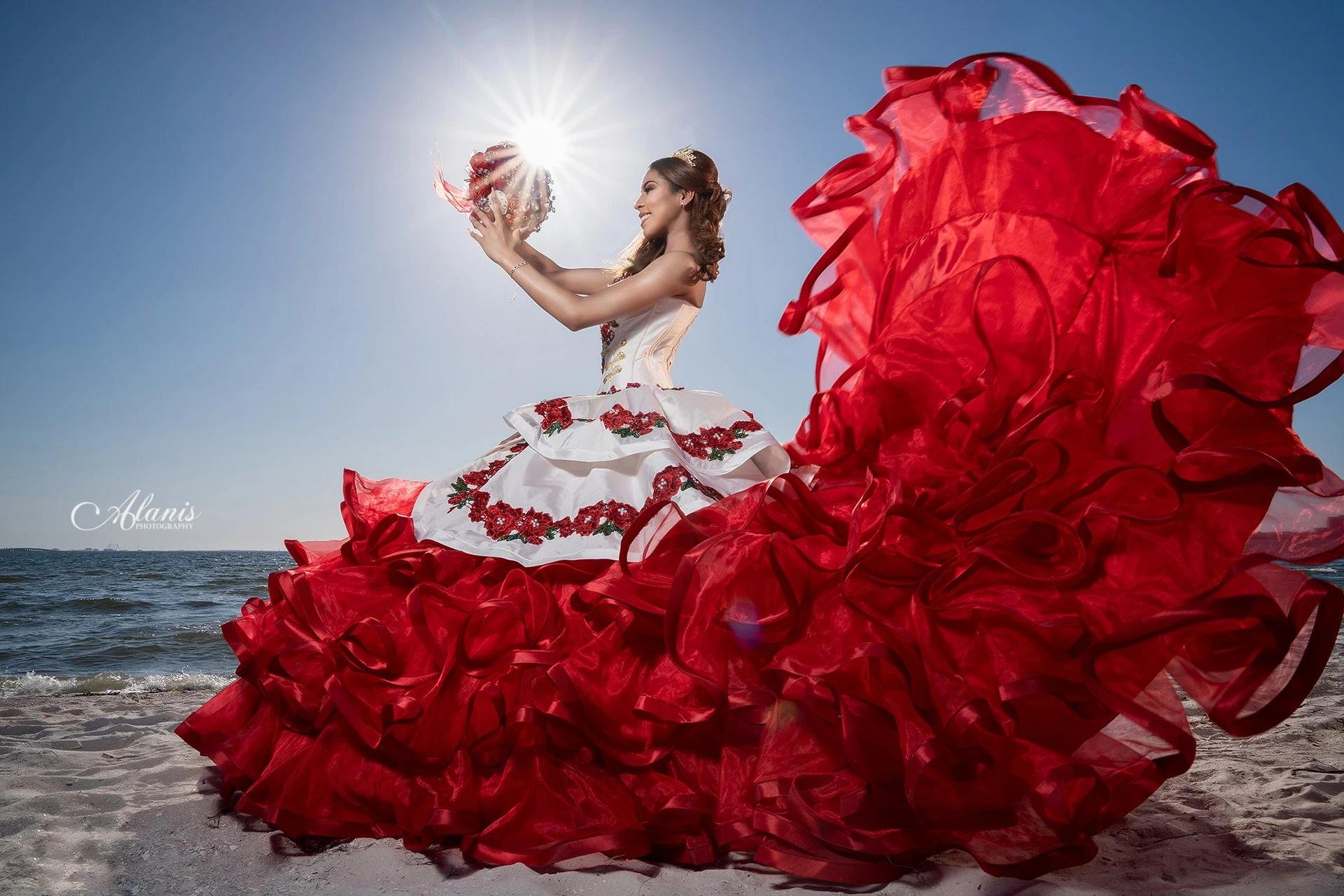 Red quinceañera gown flying beside the sea