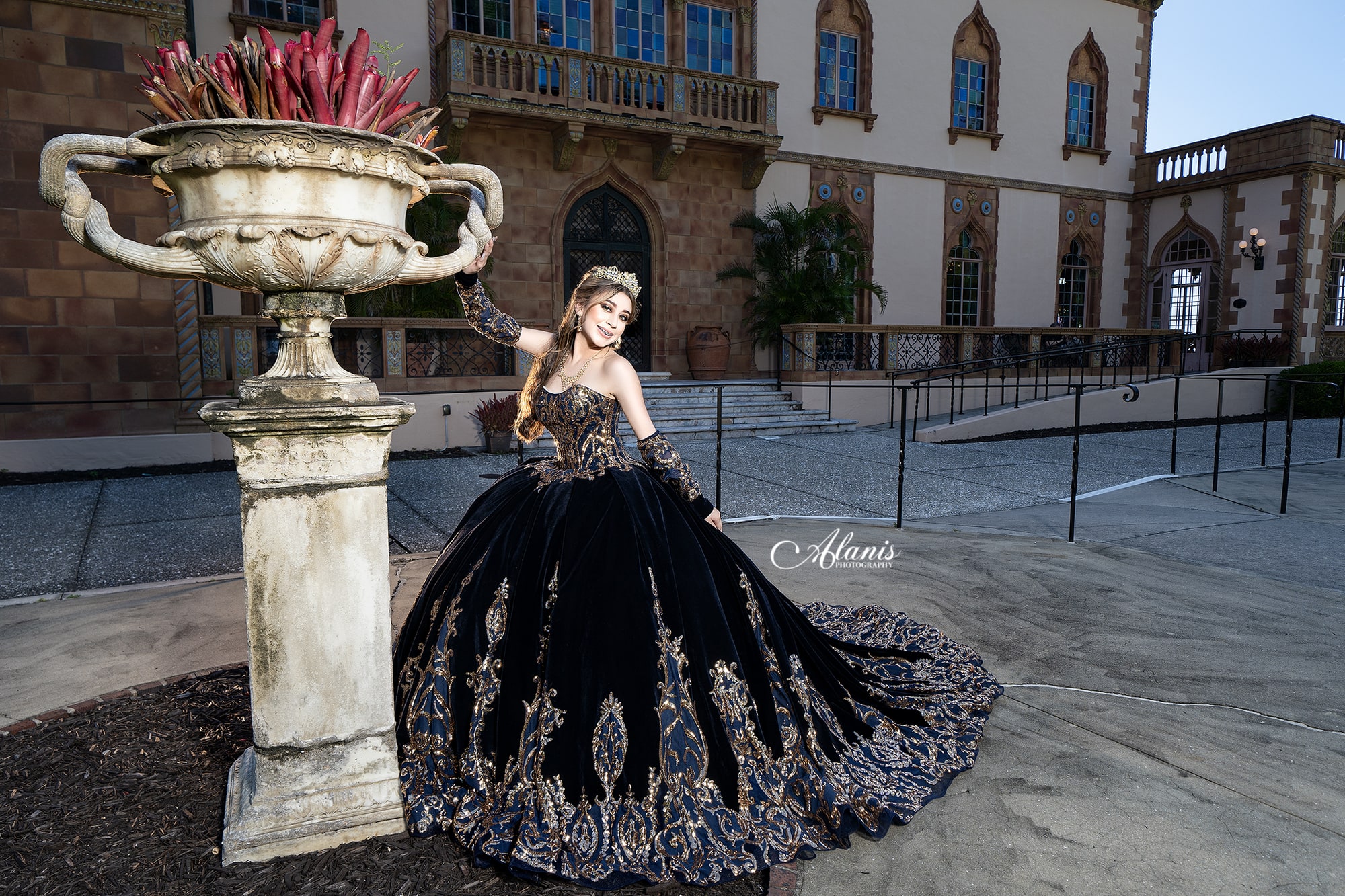 Quinceañera in a black ball gown at a historic courtyard