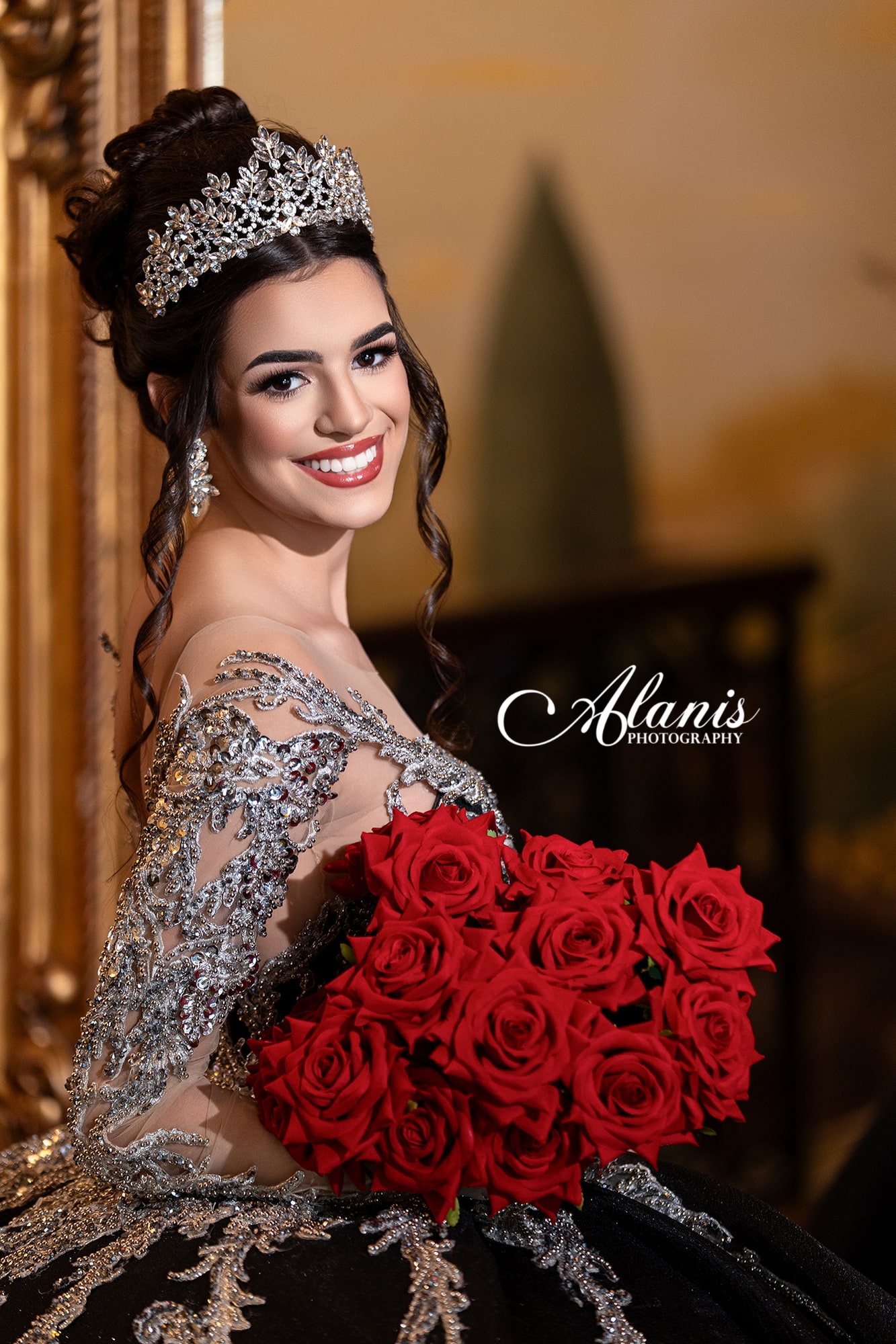 Quinceañera in a black gown holding red roses