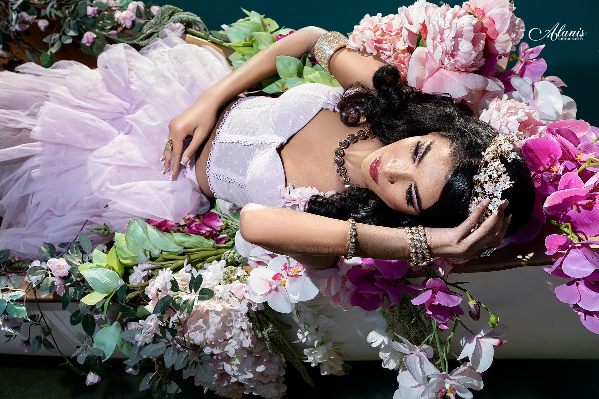 Quinceañera resting among pink flowers