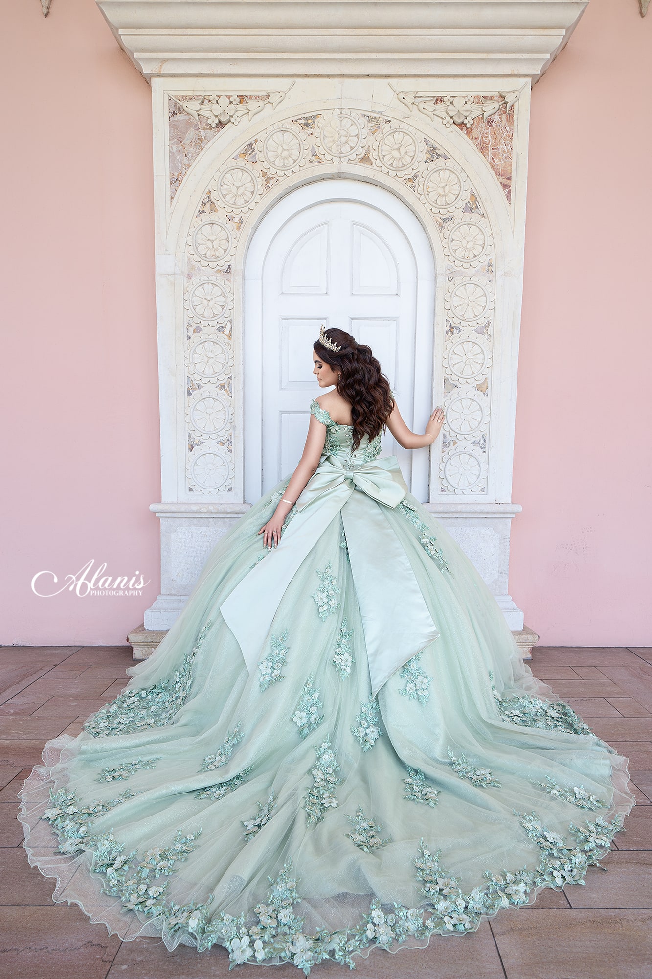 Mint quinceañera gown beneath an elegant arch