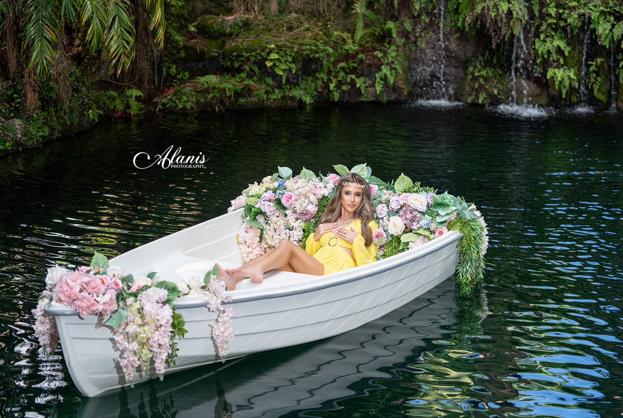 Quinceañera in a yellow dress aboard a flower-filled boat