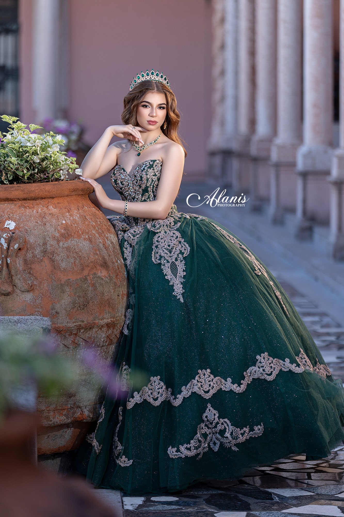 Quinceañera in a teal gown at historic stone architecture