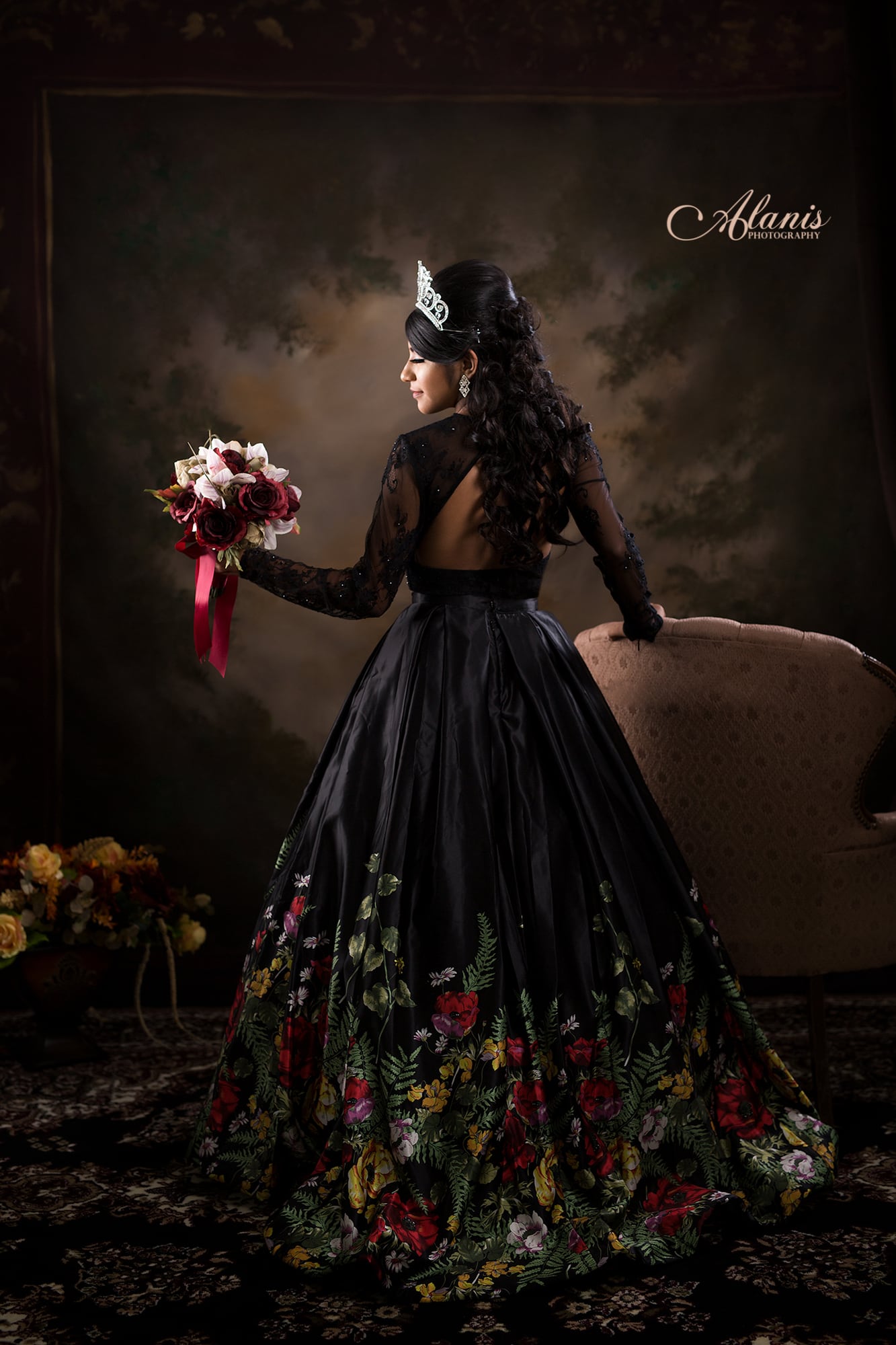 Black floral quinceañera gown in a classic studio portrait