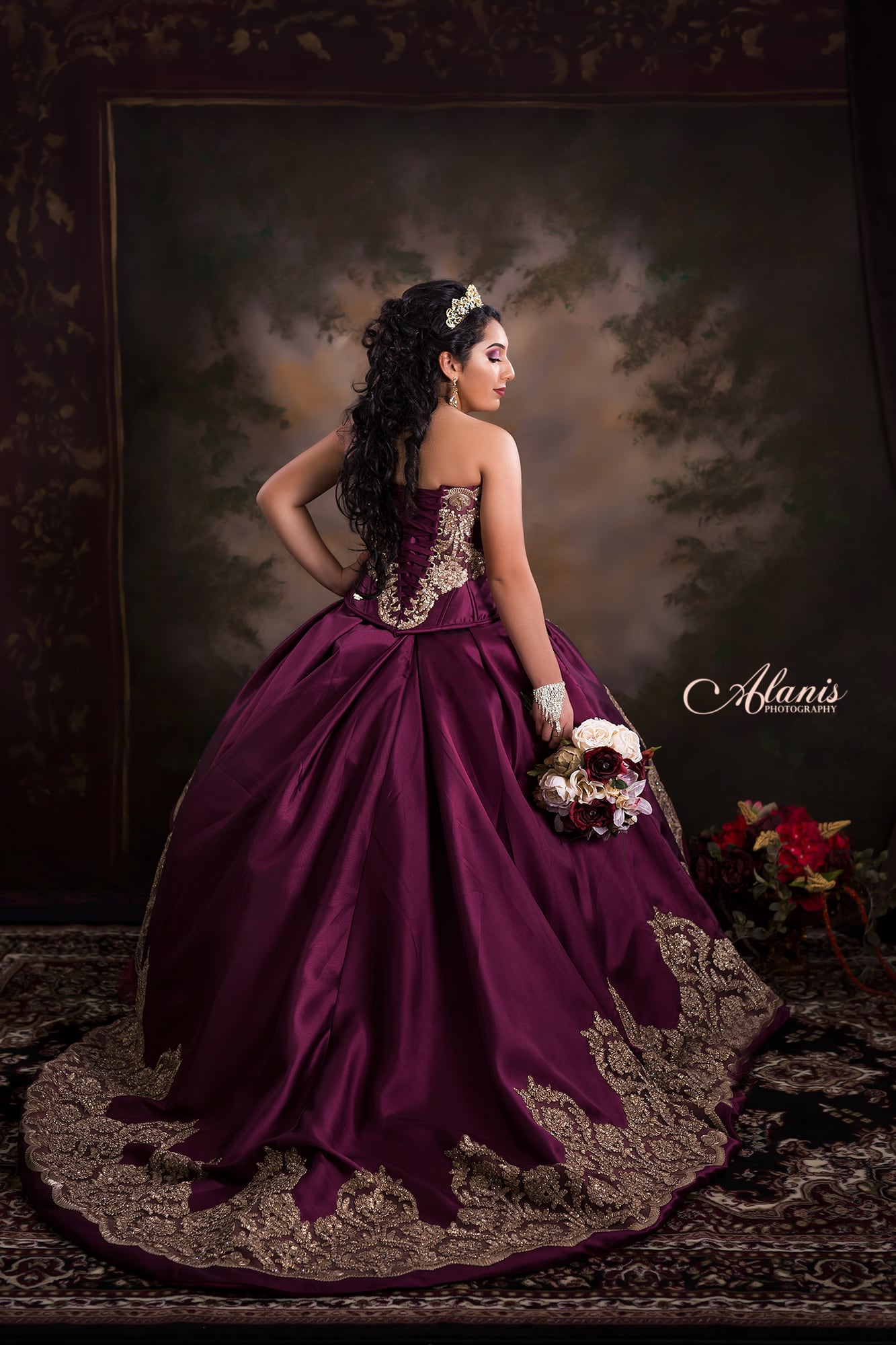 Burgundy quinceañera gown on a painterly studio backdrop
