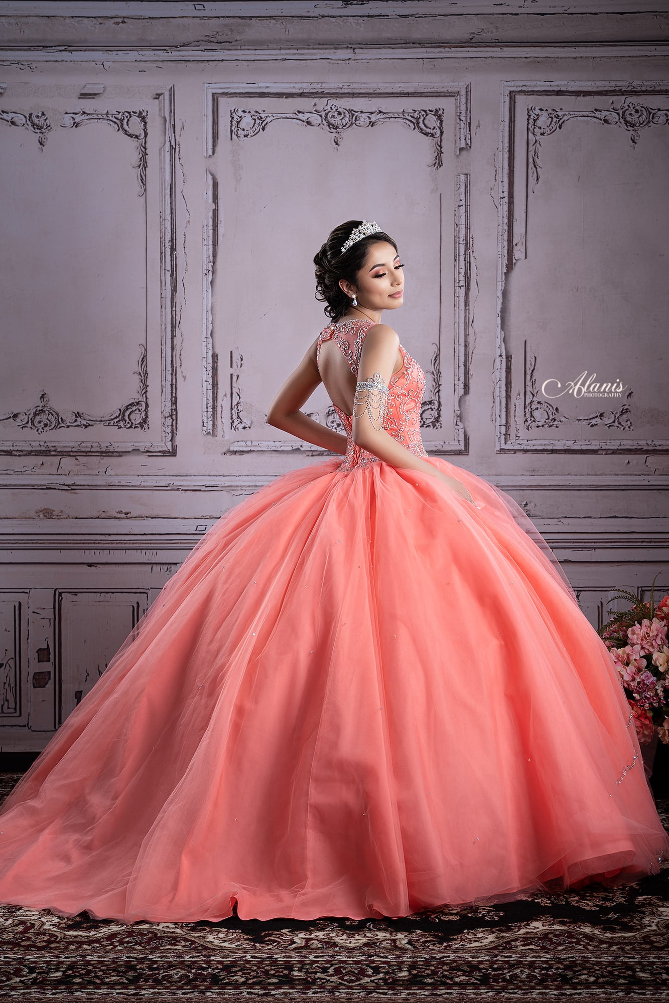 Coral quinceañera gown on an elegant studio backdrop