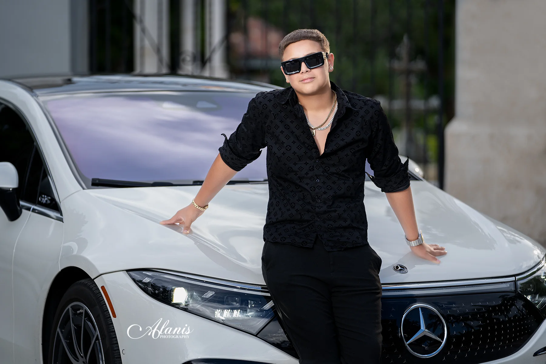 XV for Him portrait in a black outfit beside a white car