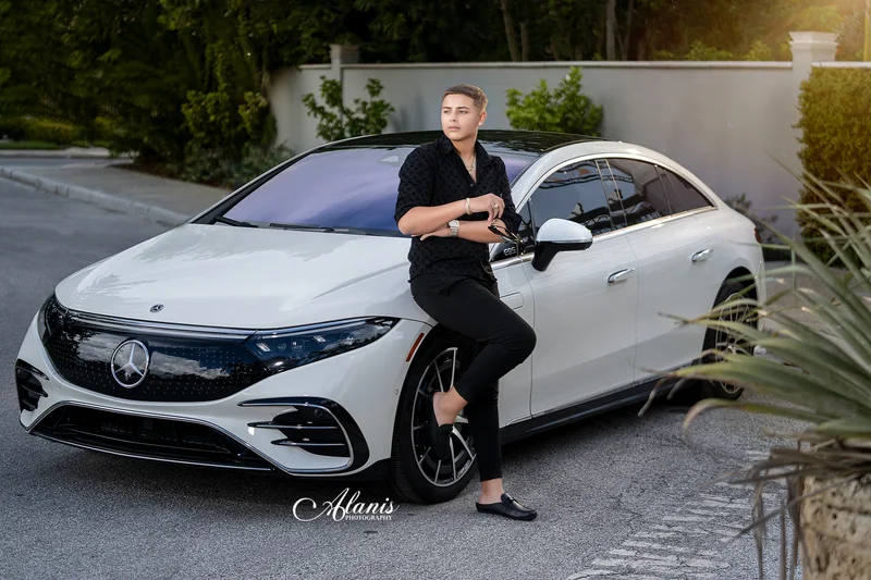 XV for Him portrait in a black outfit beside a white car